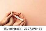 Small photo of Pregnancy test positive. Female hand hold positive pregnant test with silk ribbon on pink background. Medical healthcare gynecological, pregnancy fertility maternity people concept