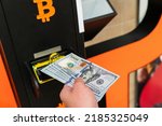 Small photo of Atm machine bitcoin cryptocurrency. Usd hundred money payment on virtual crypto currency btc wallet. Woman withdraw american dollar bill money. Atm machine finance and technology concept