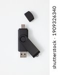 Small photo of Black pendrive with USB and micro USB ports placed on a white background. The small port has a capper which is removed.