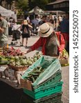 Small photo of London, UK - July, 2019. Young people shopping organic vegetables in a local farmer's market in Brockley, South-East London.