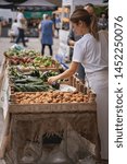 Small photo of London, UK - July, 2019. Young people shopping organic vegetables in a local farmer's market in Brockley, South-East London.