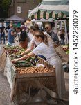 Small photo of London, UK - July, 2019. Young people shopping organic vegetables in a local farmer's market in Brockley, South-East London.