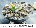 Fresh oysters with lime on a round plate. seafood dish. Oyster on the half shell. Restaurant menu, dieting, cookbook recipe.