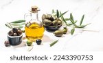 Small photo of Set of green olives, black olives and red kalmata olives and extra virgin olive oil, Products made of olives on a light background. place for text, top view
