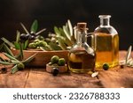 Small photo of Olive oil in bottles with black and green olives and leaves. extra virgin olive oil jars on a wooden background. place for text.