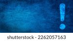 Small photo of Exclamation mark on textured abstract blue wall background