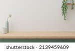Minimal cozy counter mockup design for product presentation background. Branding in Japan style with wood top green counter and warm white wall with vase plant ceramic mug. Kitchen interior