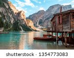 Lake Lago di Braies in Dolomiti mountains, South Tyrol, Italy. Dock with romantic old wooden rowing boats on lake. Amazing view of Lago di Braies (Braies lake, Pragser wildsee) in sunset light.