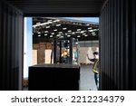 Warehouse worker open doors steel 40 feet container and ask forklift truck take out the carton box from 40 ft. container supervisor stand near by using paper clip checklist