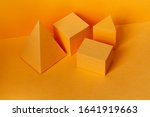 Yellow geometrical figures still life composition. Three-dimensional prism pyramid rectangular cube objects on yellow background. Platonic solids figures, simplicity concept 