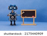 Small photo of Distance education online learning concept. Robot teacher, abstract classroom interior with empty blackboard. Blue wall background. mockup chalkboard