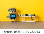 Small photo of Robot bot operator holds handset rotary telephone. The concept of a hot line phone service for customer support, consultation using answering machine robots trained artificial intellect technology.