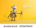 404 error page not found concept. Don't panic I'm a mechanic. Hand wrench pliers robot handyman on yellow background. Cyborg toy lamp bulb eyes head, electric wires, capacitors vintage resistors. 