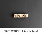 Small photo of Typo - word from wooden blocks with letters, a typographical error typo concept, random letters around, top view gray background