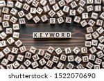 Keyword - word from wooden blocks with letters, search information that contains that word keyword concept, random letters around, top view on wooden background