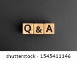 Q&A - acronym from wooden blocks with letters, questions and answers Q&A concept,  top view on grey background