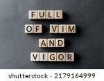 Small photo of Full of vim and vigor - phrase from wooden blocks with letters, full of energy and life concept, gray background