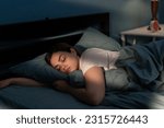 Small photo of Young female sleeping peacefully in her bedroom at night. Relaxing at nighttime. Copy space
