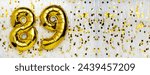 Small photo of Gold foil balloon number, digit eighty-nine. Birthday greeting card with inscription 89. Anniversary celebration. Banner. Golden numeral, white background. Numerical digit. Copy space
