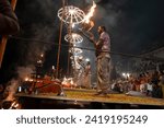 Small photo of Varanasi , India - 8 December 2023, Main famous scene of Aarti of Banaras Ghat priest worshiping with oil lamp and incense sticks at dasaswamedh ghat in Varanasi Uttar Pradesh India