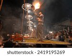 Small photo of Varanasi , India - 8 December 2023, Main famous scene of Aarti of Banaras Ghat priest worshiping with oil lamp and incense sticks at dasaswamedh ghat in Varanasi Uttar Pradesh India