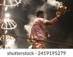 Small photo of Varanasi , India - 8 December 2023, Main famous scene of Aarti of Banaras Ghat priest worshiping with oil lamp and incense sticks at dasaswamedh ghat in Varanasi Uttar Pradesh India