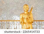 Gold Phra Sivali statue standing front of shiny wall. Ancient Buddha Phra Sivali statue widely venerated among for Thai people and foreign travelers respect praying at temple.