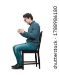 Small photo of Side view full length hysterical and passionate businessman sitting on chair, keeps fists tight, shouting and screaming, isolated on white background. Business worker celebrates success like crazy.
