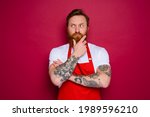 Small photo of doubter isolated chef with beard and red apron
