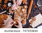 Christmas bakery. Friends decorating freshly baked gingerbread cookies with icing and confectionery mastic, view from above. Festive food, family culinary, Christmas and New Year traditions concept