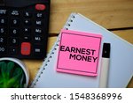 Small photo of Earnest Money write on sticky note with wooden table background