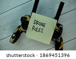 Drone Rules write on sticky notes isolated on Wooden Table.
