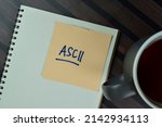 Small photo of ASCII write on sticky notes isolated on Wooden Table.