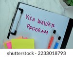 Small photo of Concept of Visa Waiver Program write on paperwork isolated on Wooden Table.