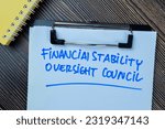 Small photo of Concept of Financial Stability Oversight Council write on paperwork isolated on Wooden Table.