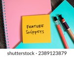 Small photo of Concept of Feature Snippets write on sticky notes isolated on Wooden Table.