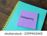Small photo of Concept of Taxonomy write on sticky notes isolated on white background.