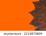 Small photo of Autum leaves in mandala shape flat lay on orange background. Meditative zen concept. Design Background.