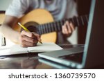 songwriter thinking and writing notes,lyrics in book at studio.man playing live acoustic guitar.concept for musician creative.artist composer in work process.people relaxing time with instrument