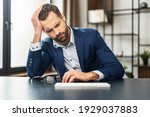 Small photo of Mature exhausted businessman thinking about budget and future of his company, overworked, bankrupt, unmotivated man sitting at keyboard, feeling stress and disinterest in work, lost the court case