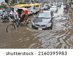 Small photo of Dhaka, Bangladesh - May 25, 2022: Vehicles try to drive through a flooded street in Dhaka, Bangladesh. Encroachment of canals is contributing to the continual water logging in the Capital Dhaka.