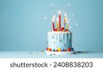 Small photo of Colorful celebration birthday cake with colorful birthday candles and sparklers against a blue background