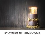 Chocolate birthday cake with gold candles
