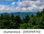 A scenic view of the surrounding mountains, trees, and sky at Mount Mitchell State Park, near Burnsville, North Carolina.
