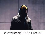 Small photo of Hooded criminal in dark. Mystery man with hood. Gangster in urban street. Hooligan in hoodie. Stalker with hidden face. Unknown suspicious thief, burglar, hacker or terrorist with grunge background.
