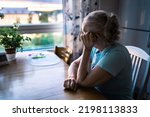 Sad old woman. Depressed lonely senior lady with alzheimer, dementia, memory loss or loneliness. Elder person looking out the home window. Sick patient with disorder. Pensive grandma. Widow with grief