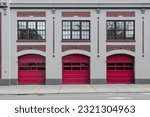 3 red garage doors at a modern fire station in downtown Seattle with red brick highlights