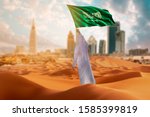 Saudi young Arab man holding Saudi Arabia  flag, celebrating the national day