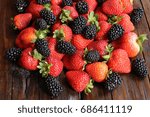 Strawberries and blackberries on a wooden table