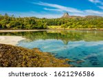 Isle of Eigg, Small Isles, Hebrides, Scotland.  A beautiful bay at low tide with silver sands and An Sgurr in the background, also reflected in the clear blue waters. Horizontal, space for copy